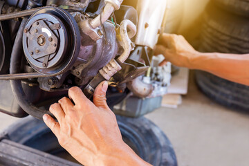 Hands of Auto mechanic working on car engine in mechanics garage, Repair and Maintenance service