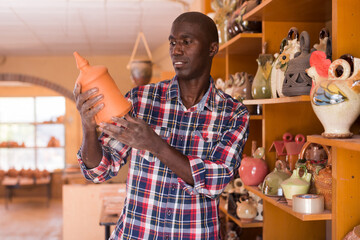 Wall Mural - Afro-american shopper chooses handcrafted ceramic products. High quality photo