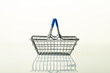empty grocery cart on a light background with reflection