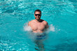 © Volodymyr - Handsome man in sunglasses swimming in pool. Summer resort. Summertime vacation.