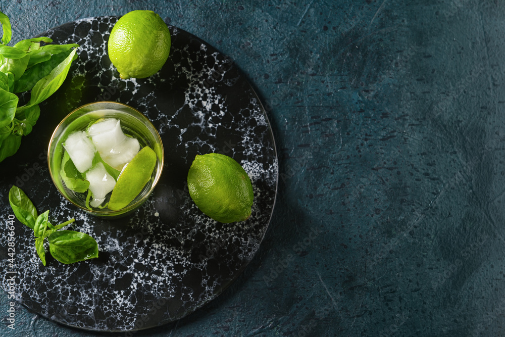 Glass of lemonade with basil on dark background