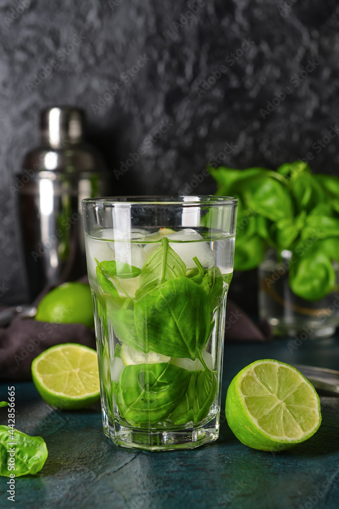 Glass of lemonade with basil on dark background