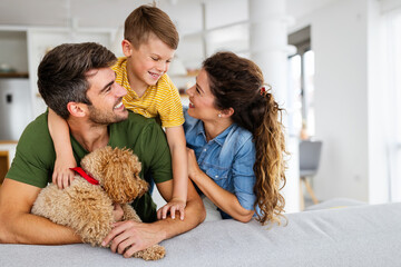 Wall Mural - Portrait of happy family with a dog having fun together at home.