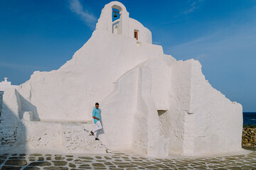 Wall Mural - Mykonos Greece, Young man at the Streets of old town Mikonos during a vacation in Greece, Little Venice Mykonos Greece. 