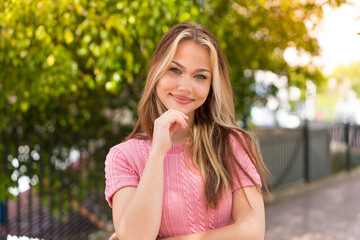 Wall Mural - Young pretty blonde girl at outdoors With happy expression