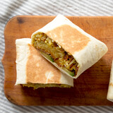 Fototapeta Tulipany - Homemade Breakfast Egg Burrito with Avocado and Bacon on a rustic wooden board, view from above. Flat lay, overhead, top view.