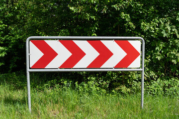 Road sign with red arrows pointing to the right