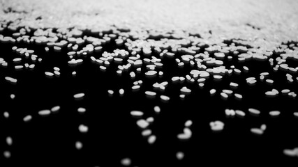 Wall Mural - Texture of scattered rice on a black background