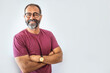 Leinwandbild Motiv Portrait of happy mature man wearing spectacles and looking at camera indoor. Man with beard and glasses feeling confident.  Handsome mature man posing against a grey background