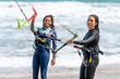 © ADDICTIVE STOCK - Multiracial kitesurfers interacting on shore against stormy sea