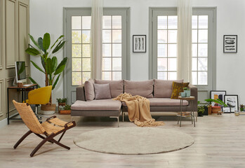 Grey sofa and working table computer style in the living room in front of the window, pillow carpet and curtain style, green interior plant.