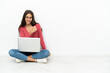 © luismolinero - Young French girl sitting on the floor with her laptop celebrating a victory