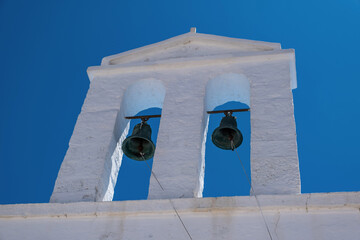 Small church belfry detail, white color chapel on clear blue sky background. Greece.