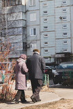 Fototapeta  - Elderly People Walking Home Together In Spring In City.