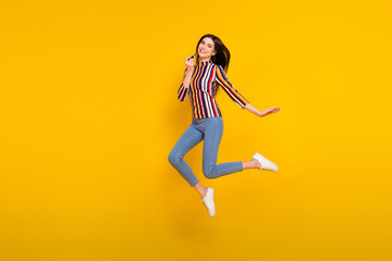 Poster - Full body profile side photo of young woman happy positive smile jump up apply makeup pomade isolated over yellow color background