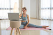 © ADDICTIVE STOCK - Calm woman using laptop before yoga practice at home