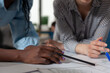 © DC Studio - Close up of diverse architect women hands working on blueprint plans at desk. Professional engineer team designing construction layout for building model maquette project design