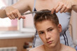 © Viacheslav - Cutting the hair of a young guy at home due to the lockdown and quarantine coronavirus epidemic. Parents and relatives help each other get their hair without going to the hairdresser