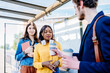 © Iryna - Language barrier concept. Handsome man offering coffee to an attractive positive african american woman at bus stop outdoor. How acquaintances with man concept.