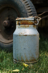 Aluminum old milk can in front of old horse cart.