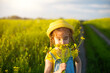 © Ольга Симонова - A girl in a yellow summer field sniffs a bouquet of flowers. Sunny day, holidays, allergy to flowering, freedom
