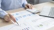 © Puwasit Inyavileart - Asian business women are analyzing graphs, financial statistics and calculating corporate returns in private offices, Market research reports and income statistics, Financial and Accounting concept.