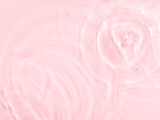 Fototapeta Tulipany - Pink water surface color background with ripples, circles and drops
