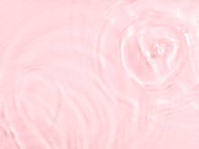 Pink Water Surface Color Background With Ripples, Circles And Drops