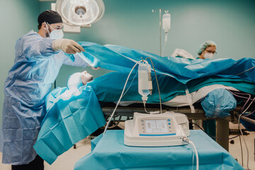 Wall Mural - Medical doctors team preparing patient in operating room at hospital - Focus on ultrasonic equipment