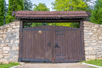 Wall Mural - Retro countryside wooden gate with with stone wall in vintage style, close up