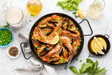 Fototapeta Lawenda - Seafood paella ready to eat served in a paella pan, top-down view