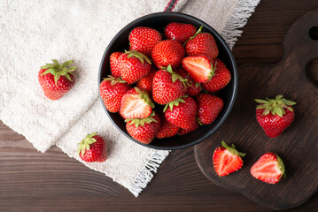 Poster - Top-down photo of many strawberries on dark table with a white natural linen towel in the corner. Beautiful composition with strawberry as a main object