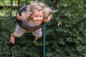 petite fille joue sur une balançoire, elle se balance et vole.