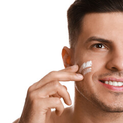 Poster - Handsome man applying face cream on white background, closeup