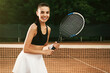 Young woman with tennis racket at court on sunny day