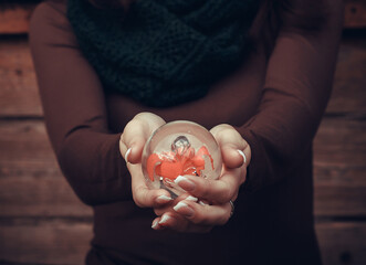 Woman holds glass ball for predictions in her hands. Fortune teller predicts fate at a seance.