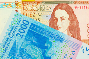 Wall Mural - A macro image of a brown ten thousand bank note from Colombia paired up with a blue, two thousand West African franc bank note.  Shot close up in macro.