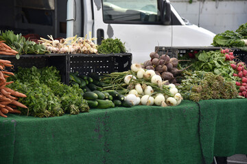 Canvas Print - Fresh produce stand with cucumbers, lettuce, onions, beets and spinach at a farmers market