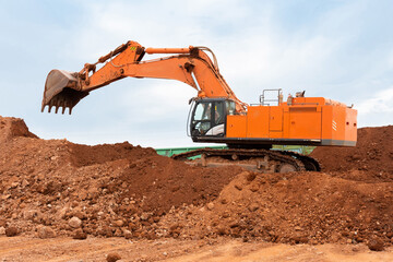 Wall Mural - large excavator loads rock with iron or bauxite mining