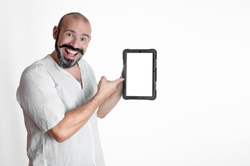 Wall Mural - Caucasian smiling man pointing and showing a tablet on a white background, dressed in white