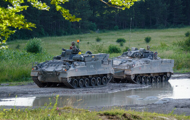 a British army Warrior FV510 light infantry fighting vehicle tank being towed by a Warrior FV512 mechanized recovery vehicle on Salisbury Plain, Wiltshire