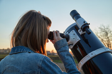 Wall Mural - woman looking at night sky with amateur astronomical telescope.