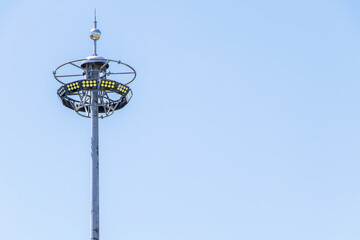 close-up photo big Spotlight pole in the sky background. Beautifully shaped set in a park to illuminate the night. technology that gives light  
for safety at night	