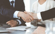 © Iryna - Business people shaking hands after contract signing in modern office. Teamwork, partnership and handshake concept