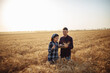 © Konstantin Zibert - Two farmers are discussing the harvest in the field. Man and woman stand with tablet in the middle of the ripe golden wheat field checking the crop quality. Rural and agricultural concept.