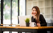 © David - Portrait of Confident asian young business woman working on laptop at her workplace at modern office.Blurred background