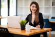 © David - Portrait of Confident asian young business woman working on laptop at her workplace at modern office.Blurred background