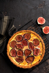 Wall Mural - Homemade quiche tart with figs, cream cheese and honey on dark brown background. Vintage style. Top view