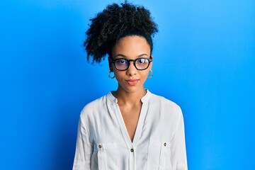 Wall Mural - Young african american girl wearing casual clothes and glasses with serious expression on face. simple and natural looking at the camera.