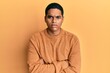 © Krakenimages.com - Young handsome hispanic man wearing casual winter sweater skeptic and nervous, disapproving expression on face with crossed arms. negative person.